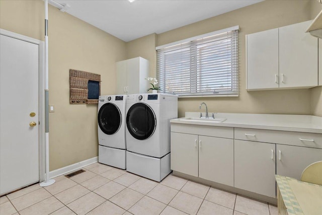 clothes washing area featuring washer and clothes dryer, a sink, light tile patterned floors, cabinet space, and visible vents