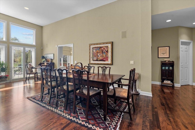 dining room with recessed lighting, a high ceiling, wood finished floors, and baseboards