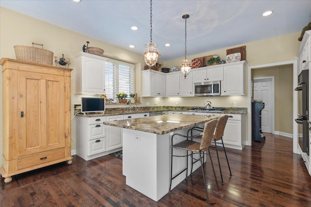 kitchen featuring white cabinetry, a kitchen breakfast bar, and stainless steel appliances