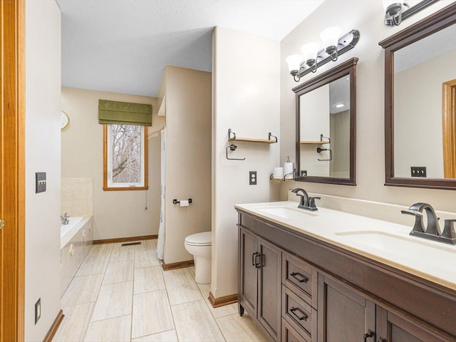 2072 Charnwood Ct, Machesney Park, IL 61115 - bathroom with double vanity, a bathtub, a sink, and toilet