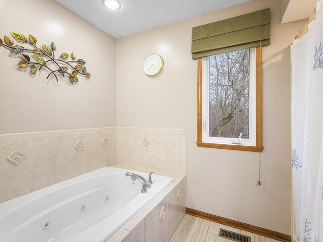 2072 Charnwood Ct, Machesney Park, IL 61115 - full bathroom featuring a whirlpool tub, visible vents, and baseboards