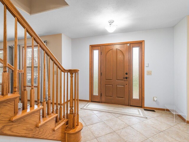 2072 Charnwood Ct, Machesney Park, IL 61115 - entrance foyer featuring stairway, baseboards, a textured ceiling, and light tile patterned floors