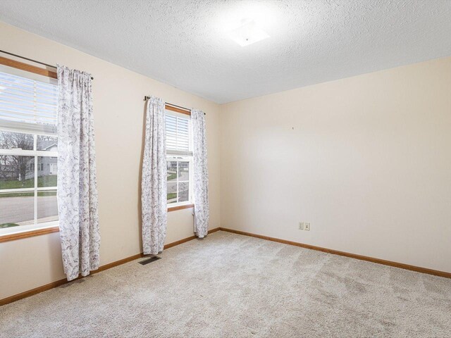 2072 Charnwood Ct, Machesney Park, IL 61115 - carpeted spare room with a textured ceiling, baseboards, and visible vents