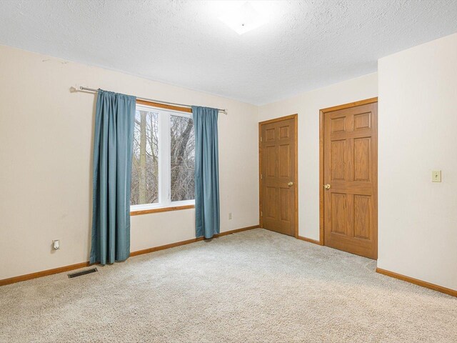 2072 Charnwood Ct, Machesney Park, IL 61115 - unfurnished room with a textured ceiling, baseboards, visible vents, and carpet floors