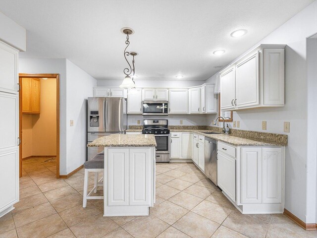 2072 Charnwood Ct, Machesney Park, IL 61115 - kitchen with baseboards, light tile patterned floors, a center island, appliances with stainless steel finishes, and a sink