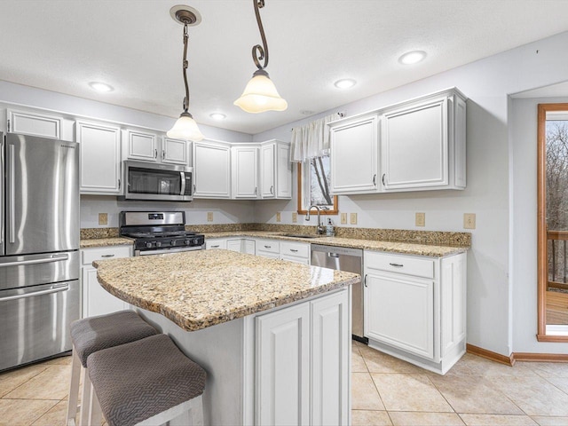 2072 Charnwood Ct, Machesney Park, IL 61115 - kitchen with light tile patterned floors, a center island, a sink, stainless steel appliances, and pendant lighting