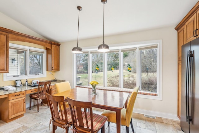 34550 N Stanley Rd, Ingleside, IL 60041 - dining area featuring stone tile floors, vaulted ceiling, baseboards, visible vents, and built in study area