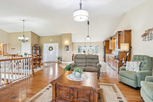 34550 N Stanley Rd, Ingleside, IL 60041 - living area featuring baseboards, visible vents, a notable chandelier, light wood-style floors, and high vaulted ceiling
