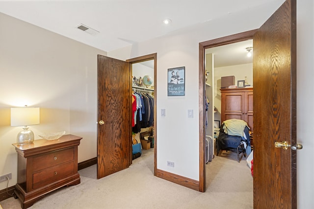 carpeted bedroom with a closet, baseboards, a spacious closet, and visible vents