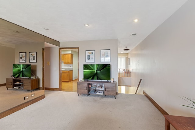 living room featuring light carpet, recessed lighting, visible vents, and baseboards