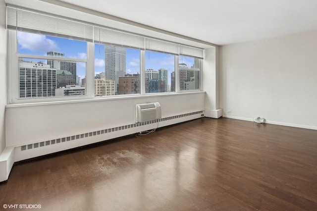 1150 N Lake Shore Dr Unit 20J, Chicago, IL 60611 - spare room featuring wood finished floors, a baseboard heating unit, baseboards, and a view of city
