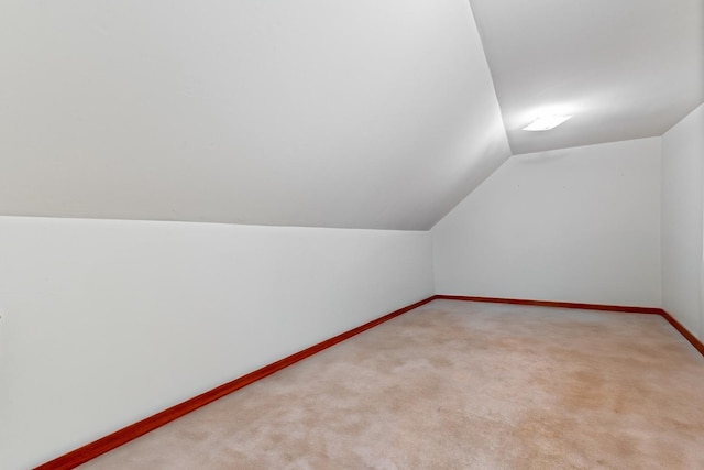 additional living space featuring baseboards, carpet flooring, and lofted ceiling
