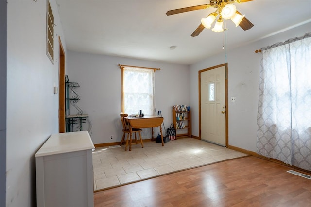 entrance foyer with light wood-style floors, baseboards, a ceiling fan, and visible vents