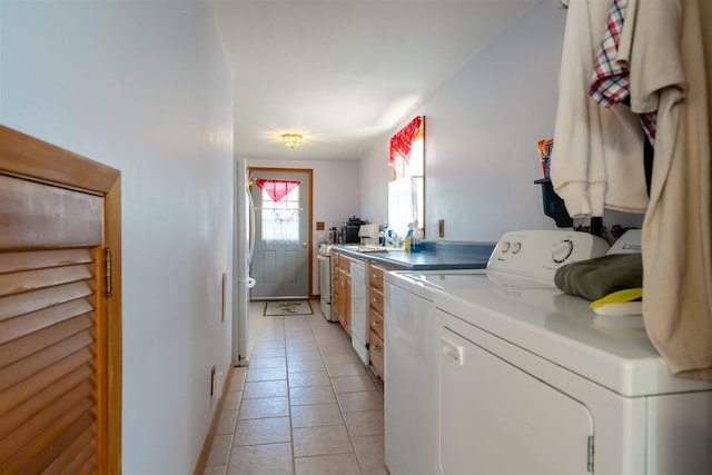 washroom with independent washer and dryer, laundry area, light tile patterned floors, and baseboards