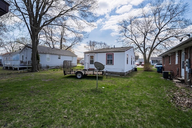 rear view of property with cooling unit and a yard