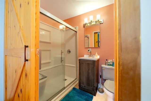 bathroom with a shower stall, vanity, and toilet