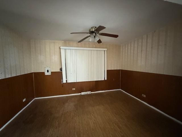 11531 S Throop St, Chicago, IL 60643 - empty room with wood walls, wainscoting, a ceiling fan, and wood finished floors