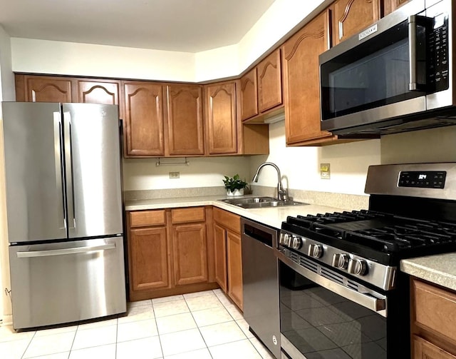 2050 Valencia Dr Unit 405, Northbrook, IL 60062 - kitchen with stainless steel appliances, a sink, light countertops, light tile patterned flooring, and brown cabinets