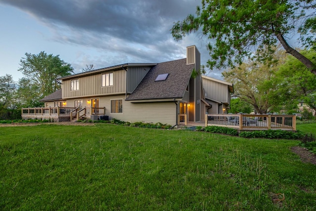 6517 Saddle Ridge Ct, Long Grove, IL 60047 - back of property featuring a deck, a chimney, a lawn, and board and batten siding