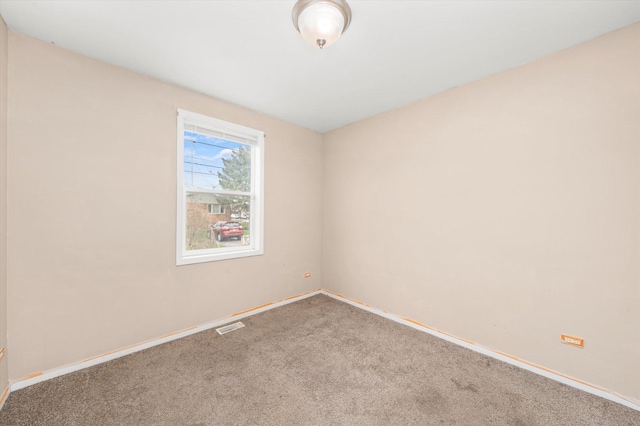 carpeted empty room featuring baseboards and visible vents