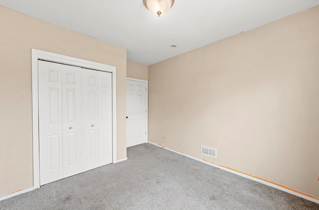 unfurnished bedroom with a closet, baseboards, visible vents, and carpet floors