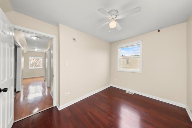 spare room with a healthy amount of sunlight, wood finished floors, ceiling fan, and visible vents