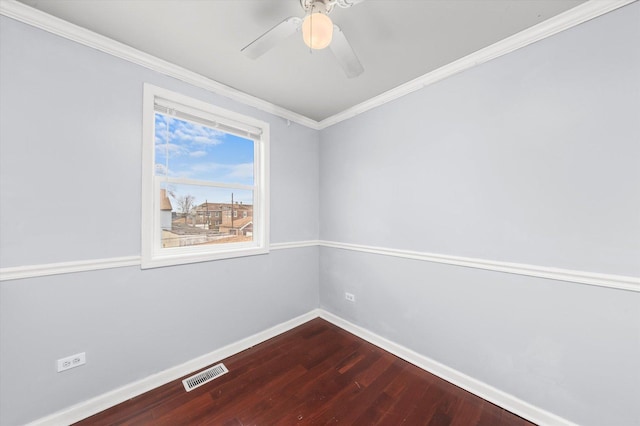 empty room with crown molding, ceiling fan, dark wood-type flooring, visible vents, and baseboards