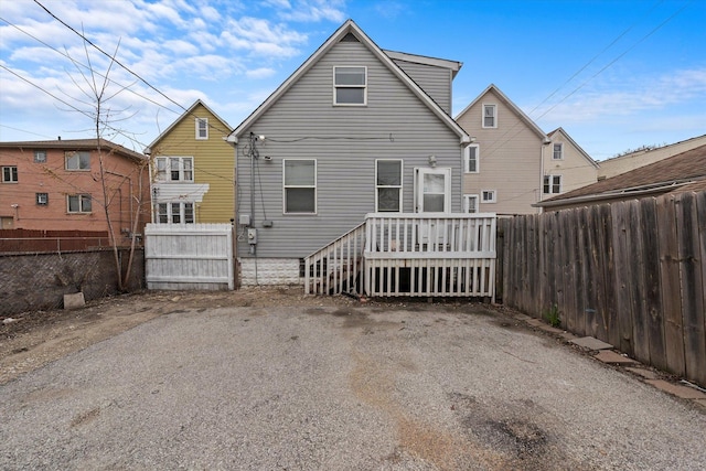 rear view of house featuring a fenced backyard