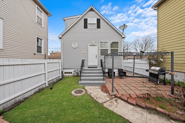 rear view of house with a patio area, a yard, and fence