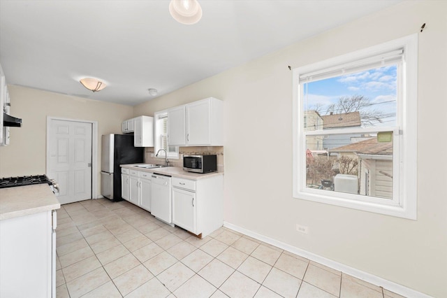 kitchen featuring white cabinetry, a sink, light countertops, stainless steel appliances, and baseboards