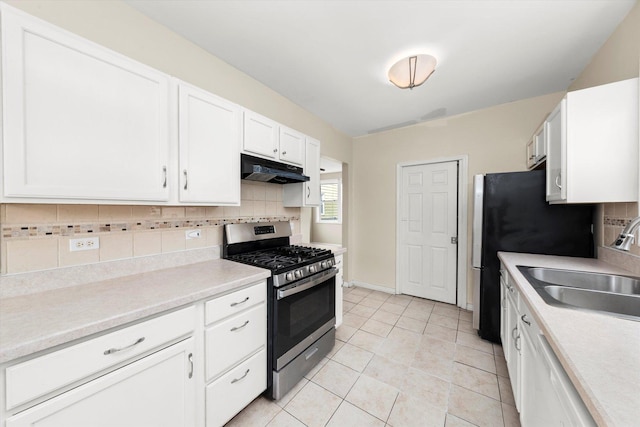 kitchen featuring white cabinetry, appliances with stainless steel finishes, under cabinet range hood, a sink, and decorative backsplash