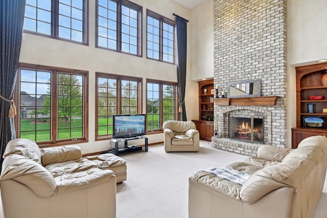 carpeted living room featuring a towering ceiling, a fireplace, built in shelves, and baseboards