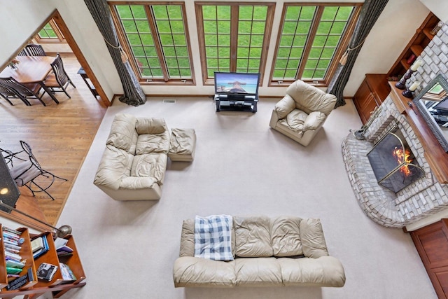 living area with a brick fireplace, baseboards, and wood finished floors