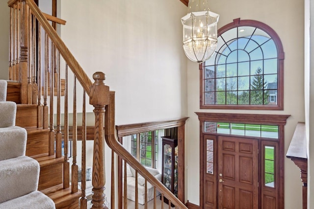 entryway with a high ceiling, a chandelier, and stairs