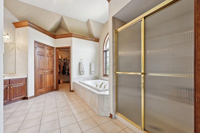 bathroom with lofted ceiling, a shower stall, vanity, a bath, and tile patterned floors