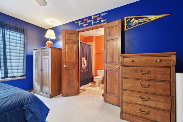 bedroom with ensuite bath and light colored carpet