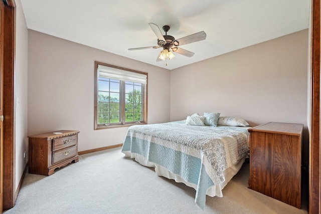 bedroom featuring light colored carpet, baseboards, and ceiling fan