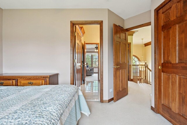 bedroom with light colored carpet and baseboards