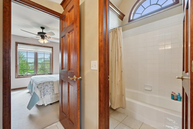 ensuite bathroom featuring a ceiling fan, shower / bathtub combination with curtain, tile patterned flooring, and baseboards