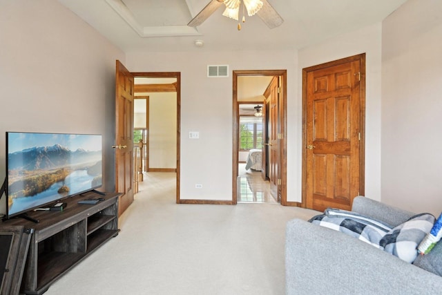 living area featuring ceiling fan, light colored carpet, and baseboards