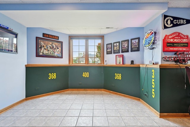 empty room with a drop ceiling and baseboards