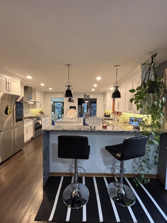 2 Rutgers Ct, Hawthorn Woods, IL 60047 - kitchen with stainless steel appliances, wall chimney exhaust hood, a peninsula, white cabinets, and decorative backsplash