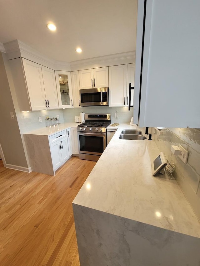 8416 Mccormick Blvd, Skokie, IL 60076 - kitchen featuring glass insert cabinets, white cabinetry, a sink, backsplash, and stainless steel appliances