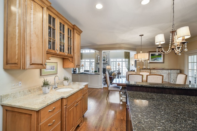 1303 Bonnema Ave, Naperville, IL 60565 - kitchen featuring a sink, crown molding, dark wood-style floors, glass insert cabinets, and light stone countertops