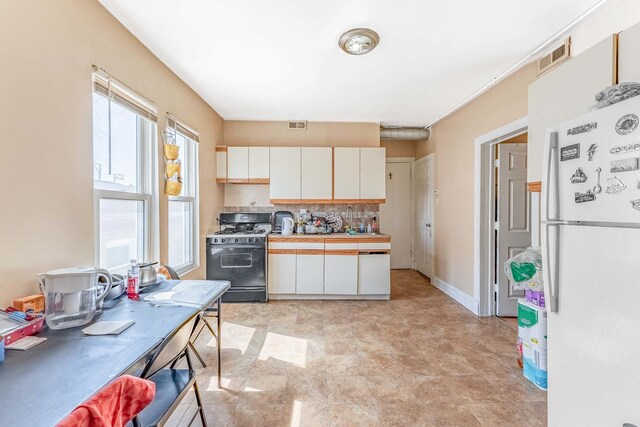 4026 N Kimball Ave, Chicago, IL 60618 - kitchen with freestanding refrigerator, visible vents, white cabinets, gas range oven, and tile counters