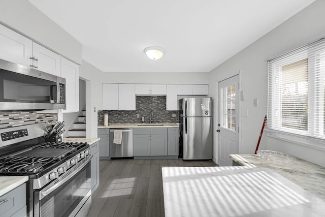kitchen featuring light countertops, decorative backsplash, a sink, and stainless steel appliances