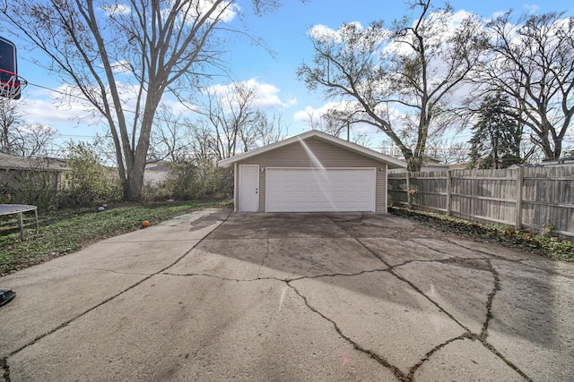 detached garage featuring a trampoline and fence