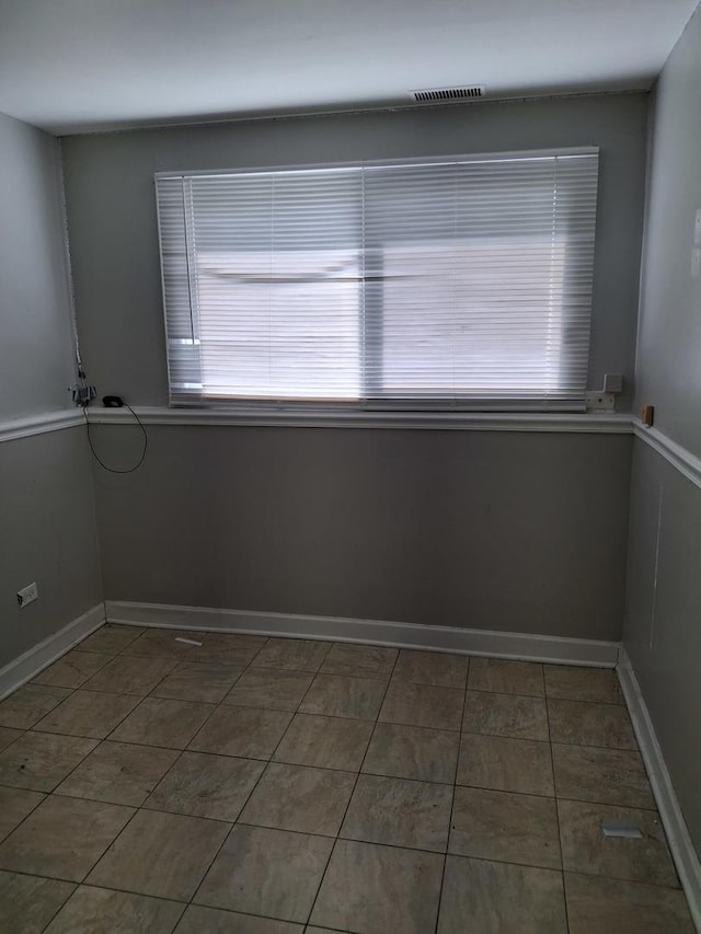 empty room with visible vents, baseboards, and plenty of natural light
