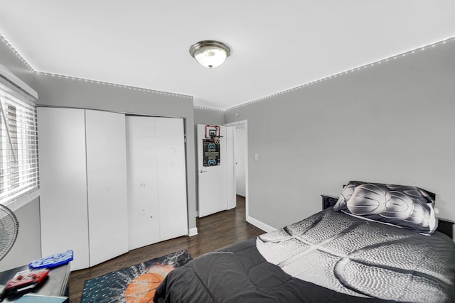bedroom featuring a closet, baseboards, and wood finished floors