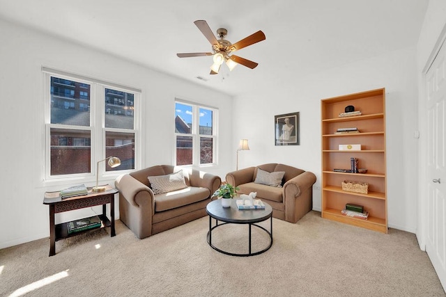 living area with carpet and ceiling fan